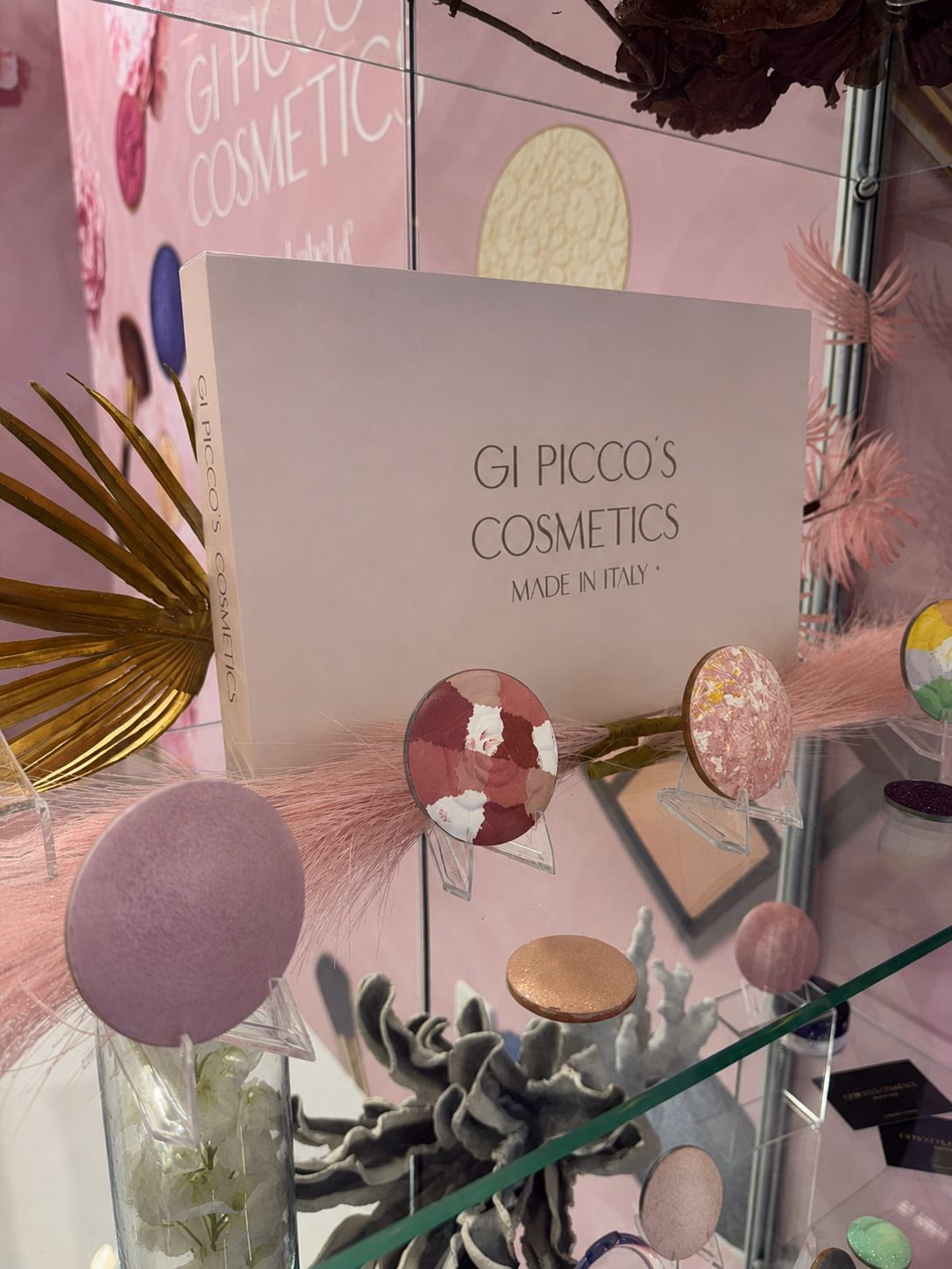 Gi Picco’s Cosmetics trade fair display with cosmetic powders and compacts.